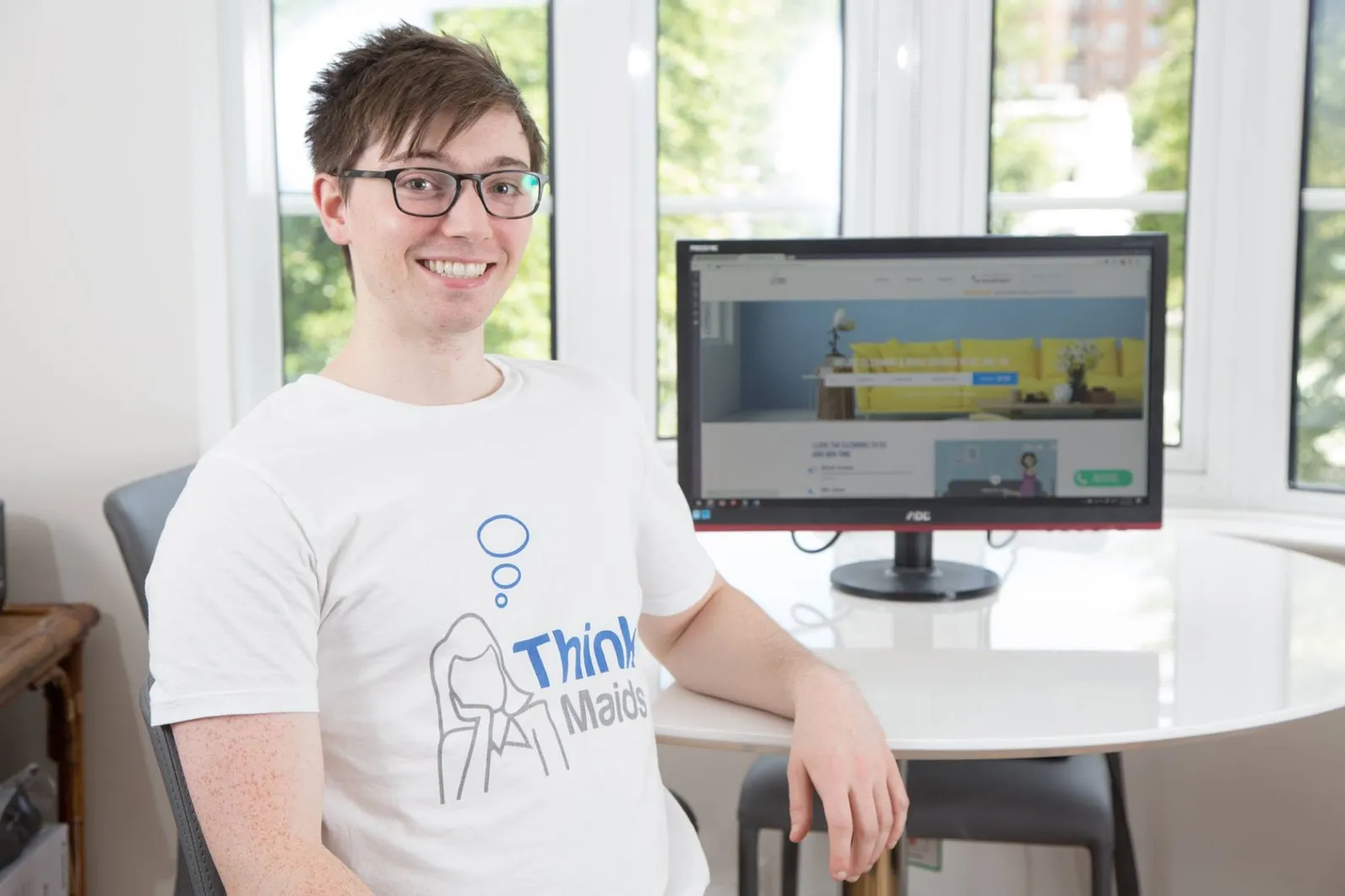 Chris Schwab in a Think Maids t-shirt beside the company's booking site